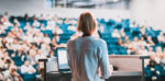 Woman delivering a presentation to an auditorium of people